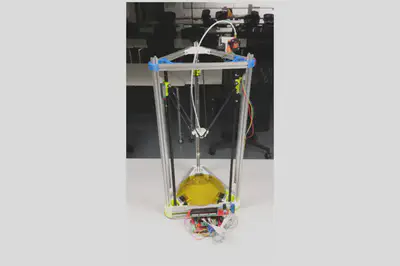 Image of the Kossel 3D printer on a desk. The Kossel has aluminum frames held in place by 3d printed pieces.