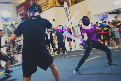 Image of me and dueling an opponent in the indoor tournament. We are both wearing protective gloves and helmets.