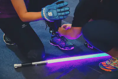 Image of the saber on the carpeted tournament floor. A friend was helping me tie my shoelaces so that I did not have to remove my gloves.